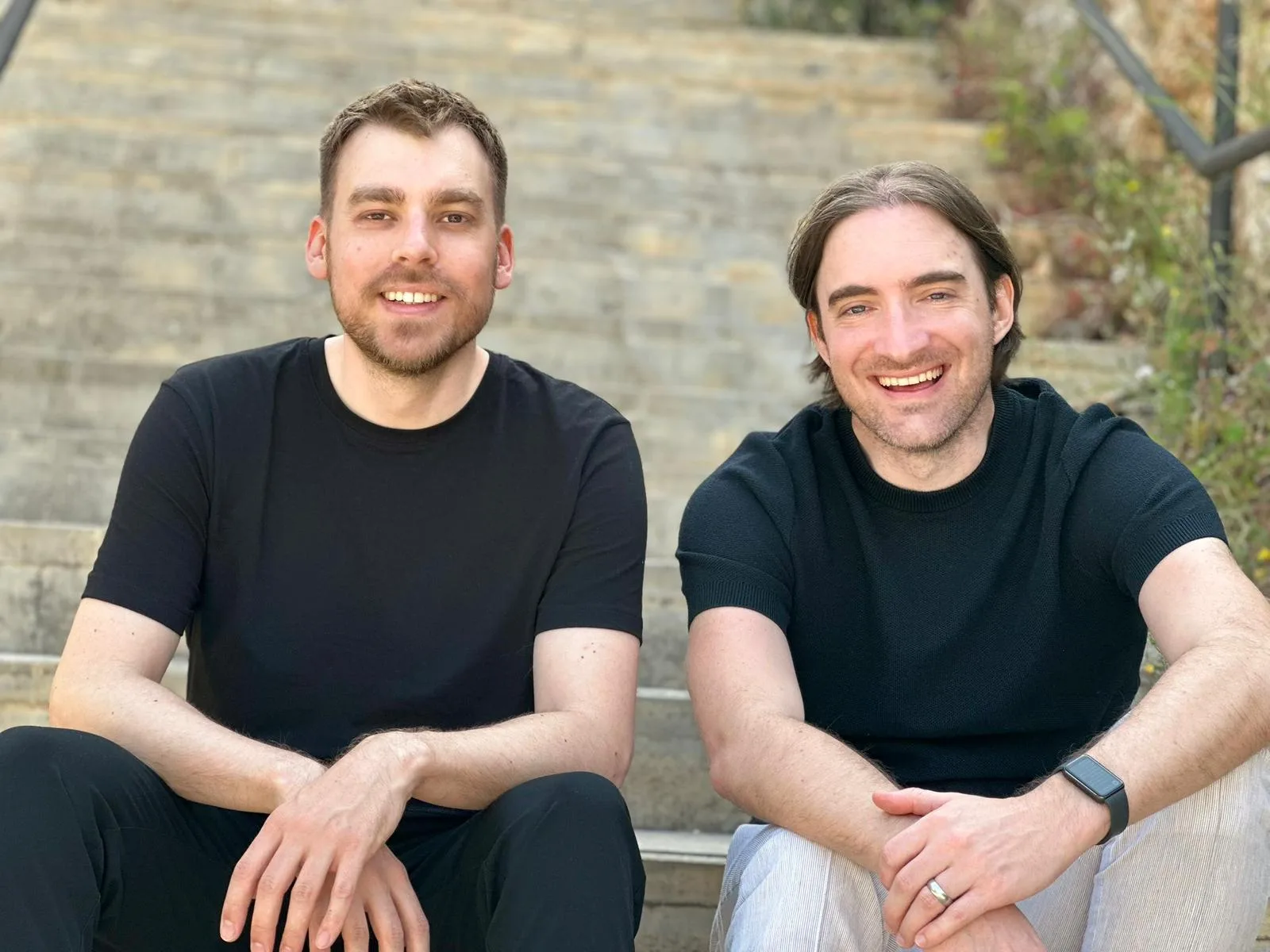 Fabian Laußmann und Hieronymus Deutsch, die Gründer von clearlea.se, sitzen lachend auf einer Steintreppe